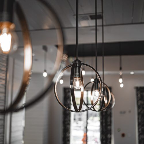 A selective focus shot of a modern lamp with a light bulb inside the building