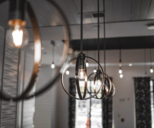 A selective focus shot of a modern lamp with a light bulb inside the building